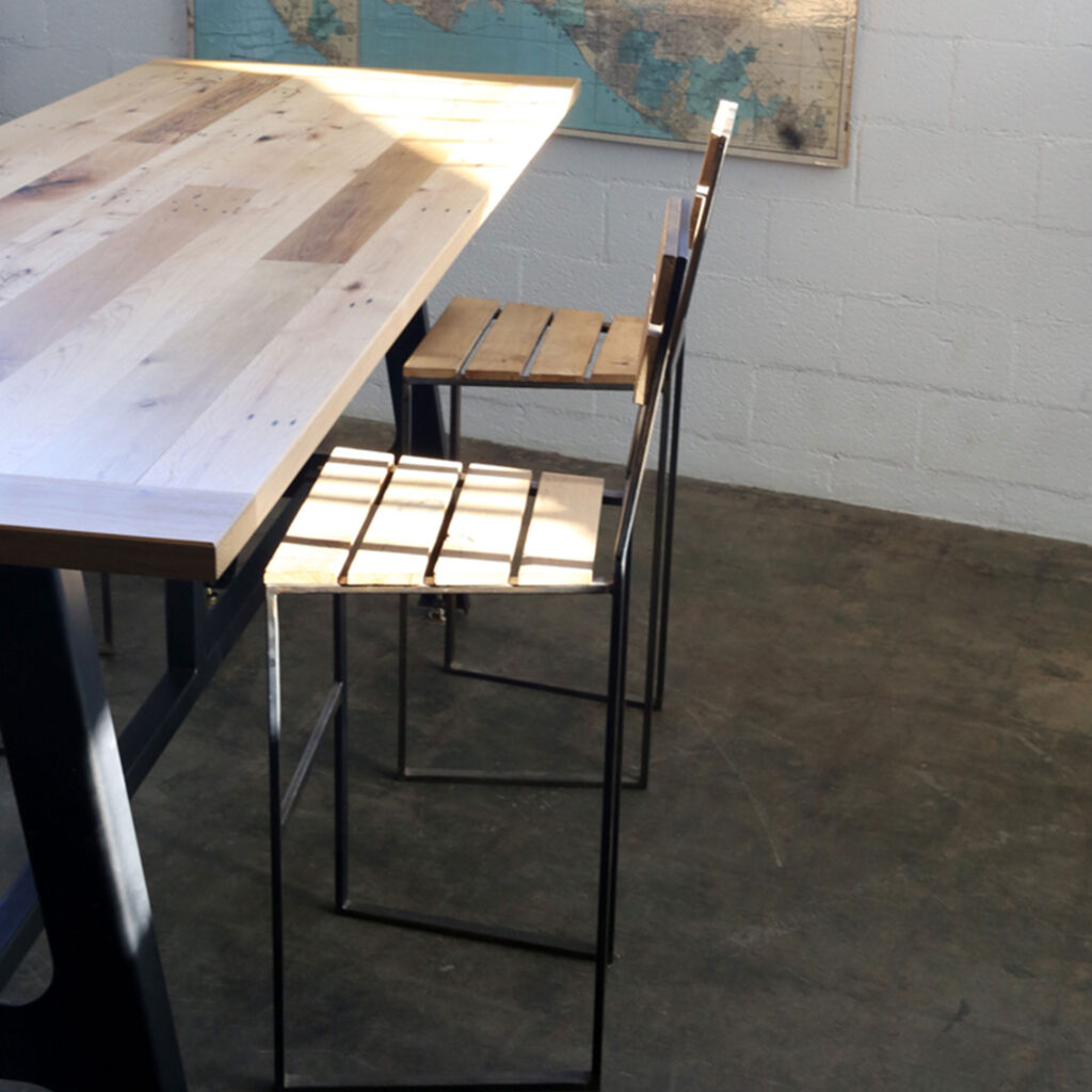 High A-Frame Dining Table, black steel A-frame legs with steel/wood bar chairs